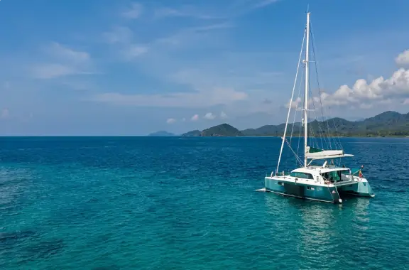 Luxury catamaran yacht anchored in calm turquoise ocean waters